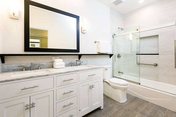Contemporary Bathroom Design with Vanity and Shower Bathtub A contemporary modern bathroom design. featuring a bathtub with glass shower stall, toilet and his and her double sink vanity. vanity mirror photos stock pictures, royalty-free photos & images
