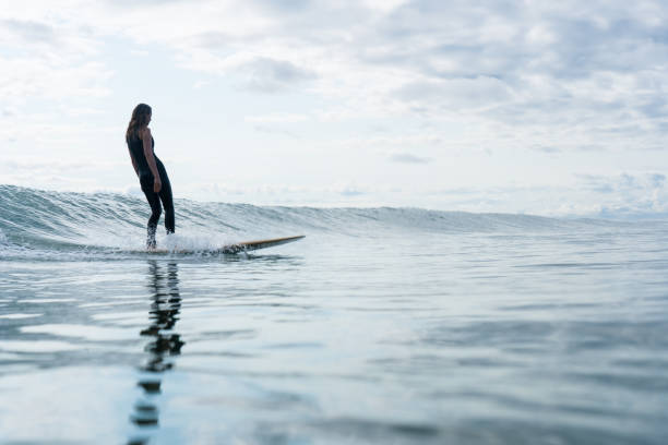 istock Surfer girl riding on the wave 1202622418