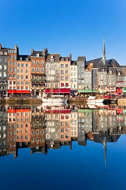 Honfleur harbour in Normandy, France. Color houses and their reflection in water. 