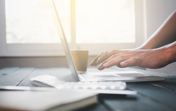 istock part of human hand while using laptop at working desk 1202626034