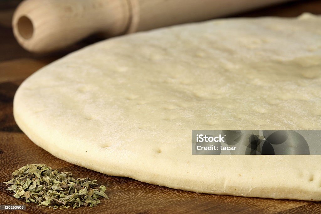pizza sheet pizza  dough sheeet and fresh oregano  on  wood cutting board with rolling pin Color Image Stock Photo