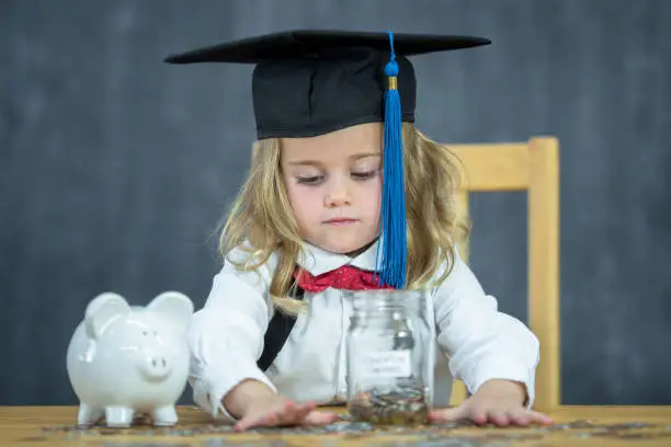 Photo of Little Girl Counting Her Education Funds stock photo