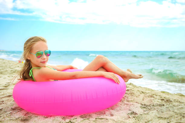 istock Happy girl lying on pink inflatable circle. 1202643928