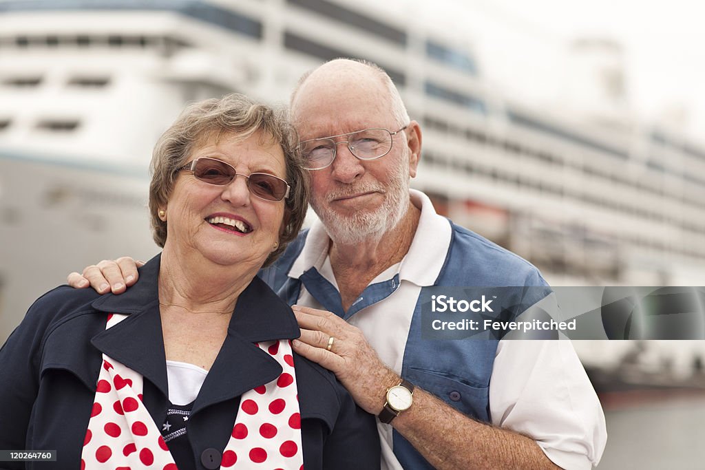 Casal sênior na praia na frente do navio de cruzeiro - Foto de stock de Cruzeiro royalty-free