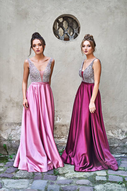 Two Beautiful Bridesmaids Girls Blonde And Brunette Ladies Wearing Elegant  Full Length Purple Violet Lilac Lavender Satin Folded Bridesmaid Dress With  Silver Sequined Camisole Top With Sequins European Old Town Location For