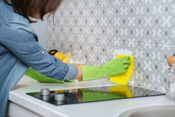 Woman in gloves with rag cleaning house in kitchen Woman in gloves with rag cleaning house in kitchen. Female washing cleaning polishing tiled wall cleaning stove domestic kitchen human hand stock pictures, royalty-free photos & images