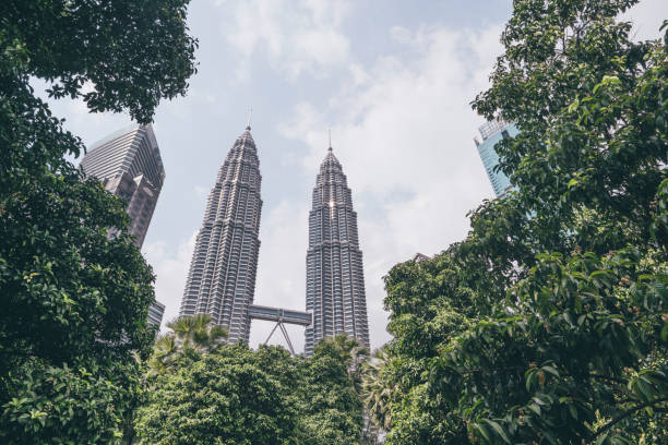 istock Kuala Lumpur skyscrapers seen through lush green trees 1202655499