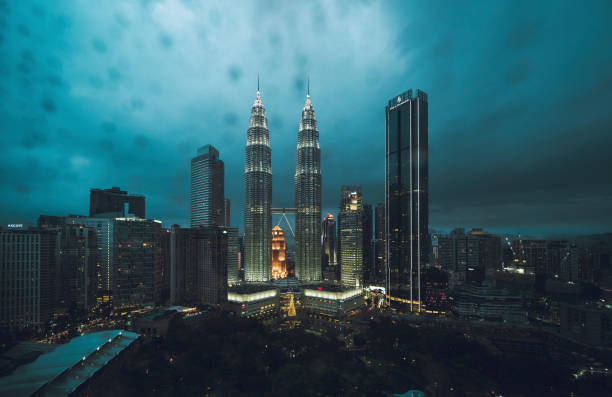 Kuala Lumpur Skyline at KLCC with Petronas Towers seen a rainy evening. Water drops on the window in front of the view.