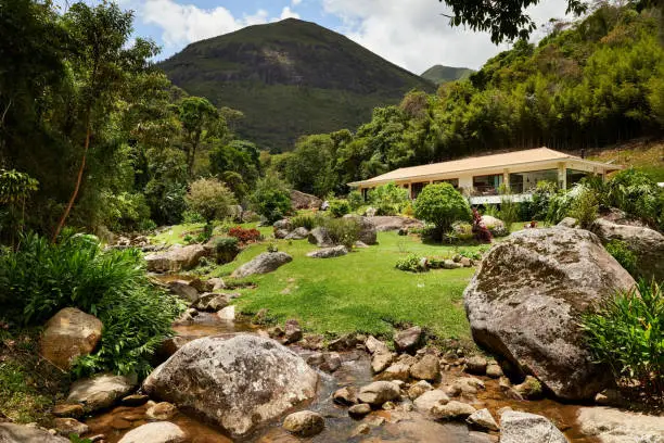 Shot of an attractive holiday resort in the middle of nature with rocks and stream of water on slope