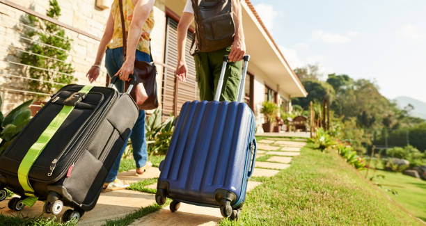 Can't wait to see the room Rear view shot of a traveler couple arriving at their holiday resort suitcase stock pictures, royalty-free photos & images