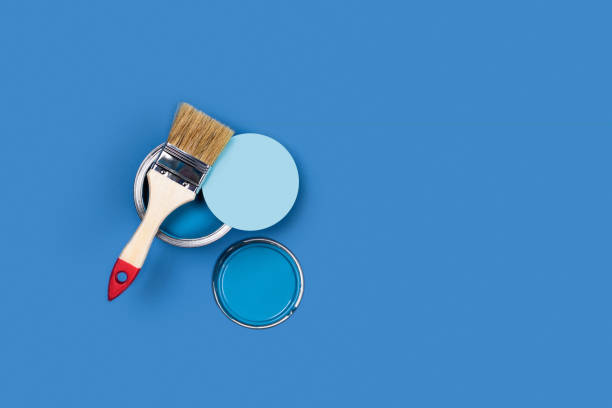 istock Blue background with paint jars and brush. 1202674259