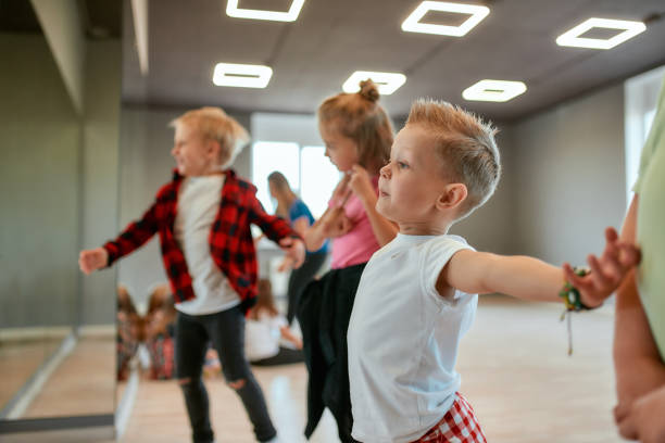 istock Modern dancers. Group of fashionable children learning a modern dance while having a choreography class. Dance studio 1202675671