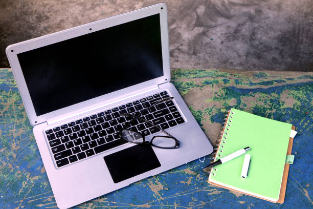 istock aptop computer, eyeglasses, notebook and pen at an outdoor park 1202676926