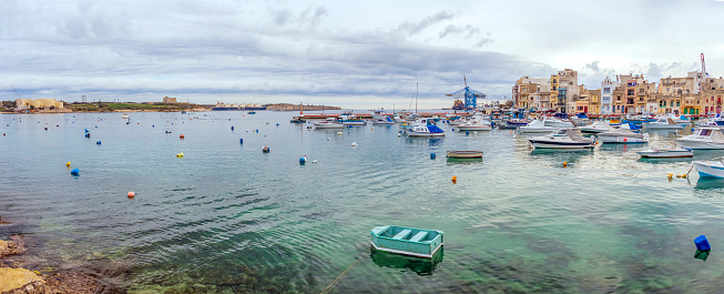 Marsaxlokk, Malta â January, 2020 : Traditional eyed colorful boats Luzzu in the Harbor of Mediterranean fishing village