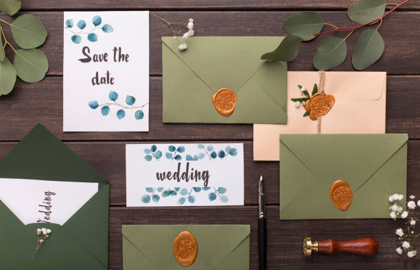 istock Wedding invitations, envelopes, branches, cards on wooden table 1202681647