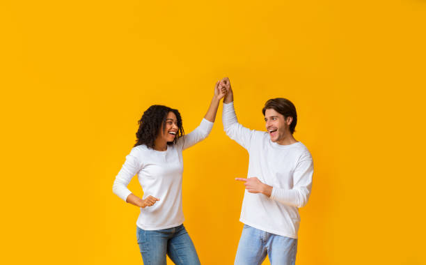 istock Cheerful Interracial Couple Fooling Together, Holding Hands And Dancing 1202682018