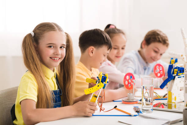 istock Happy schoolgirl at stem lesson showing her robot 1202683848