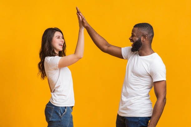 istock Joyful interracial sweethearts giving high-five to each other, clapping hands 1202684086