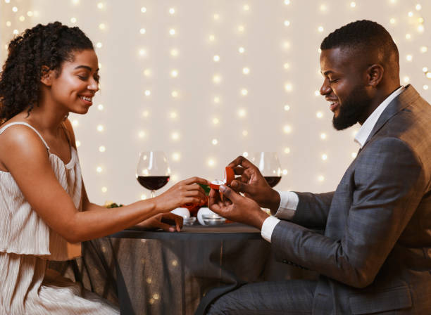istock Young black couple getting engaged in restaurant 1202684125