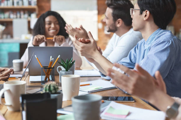 istock Young business team clapping hands on meeting, close up 1202684211