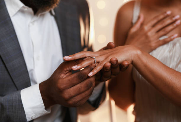 primer plano de afro hombre poniendo anillo en el dedo de la mujer - young women wedding married engagement ring fotografías e imágenes de stock