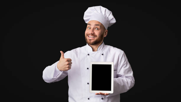 istock Cook Man Showing Tablet Screen Gesturing Thumbs-Up, Studio, Mockup 1202685028