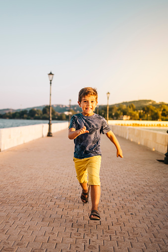 Athletic kid running on a bridge in Argostoli, Greece.