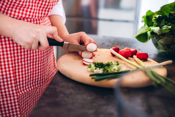 Cutting radishes and scallions on a cutting board.