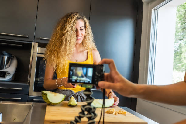 istock woman recording with a camera like a melon cutter in a kitchen 1202686664