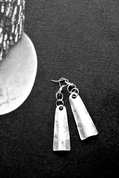 istock Silver earrings on the black background photo 1202686835