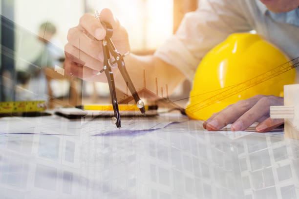 istock Engineer man and Architect drawings blueprint  at Construction Site.Home Project to Offer Management 1202686849