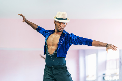 Brazilian male dancer with hat and costume practicing in studio