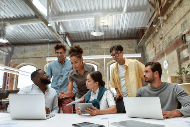 istock Successful collaboration. Young business people in casual wear using modern technologies and working together on new project while sitting in the creative office 1202687080