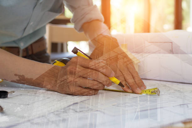 istock Engineer man and Architect drawings blueprint  at Construction Site.Home Project to Offer Management 1202687140