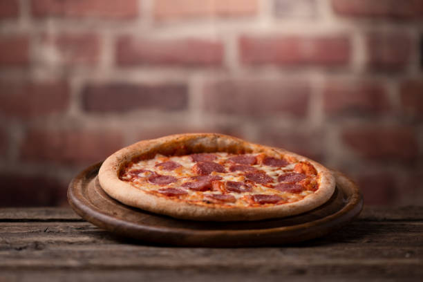 istock Pepperoni Pizza on wooden table 1202688254