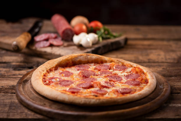 istock Pepperoni Pizza on wooden table 1202688332