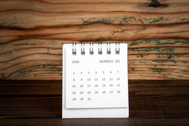 istock 2020 March. White paper calendar on a wooden table 1202688387
