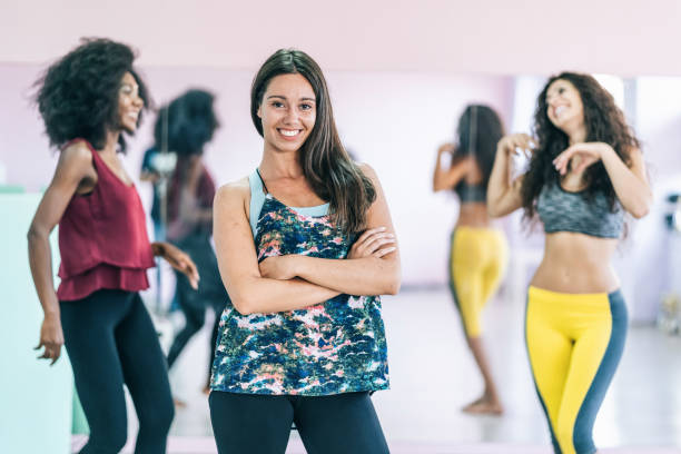 istock Female dancer standing with arms crossed in studio and posing 1202689161