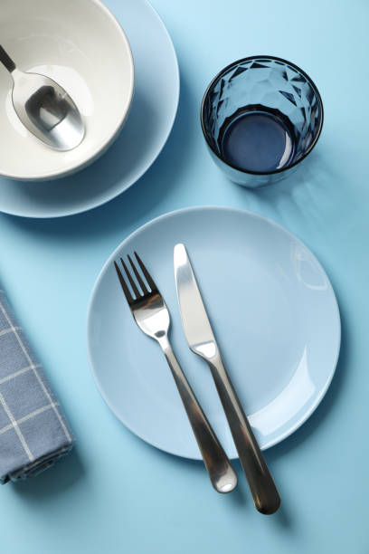 istock Tableware and cutlery on blue background, top view 1202689182