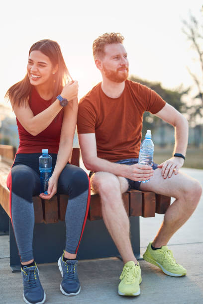 istock Modern couple making pause in an urban park during jogging / exercise. 1202690114