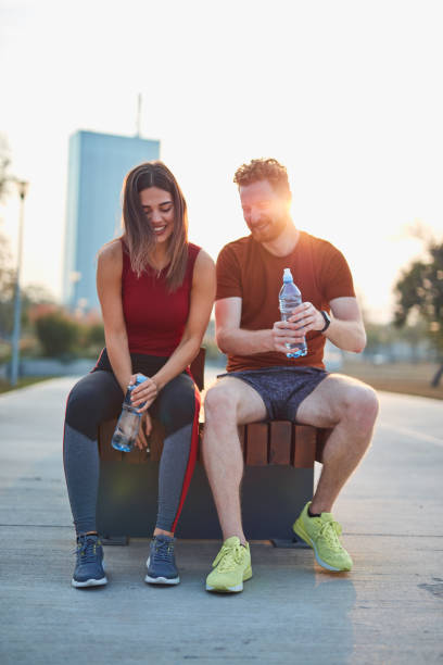 istock Modern couple making pause in an urban park during jogging / exercise. 1202690175