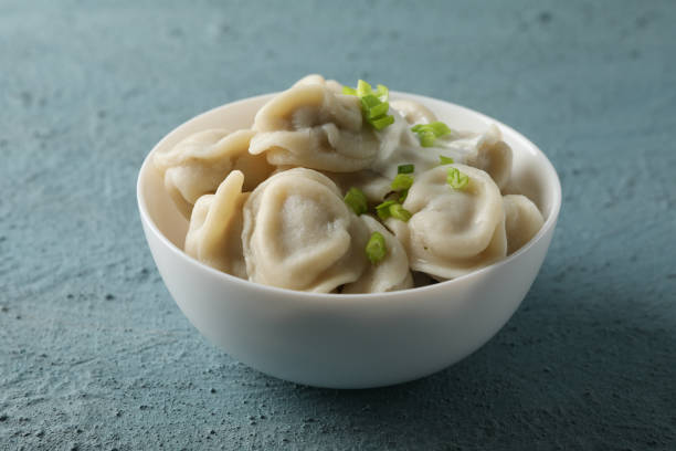istock Bowl with dumplings on blue background, close up 1202691747
