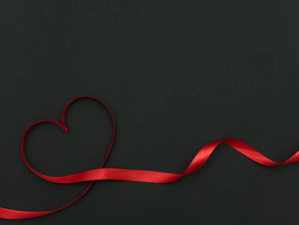 istock Hearts from ribbon on black background top view with space for your text 1202692240