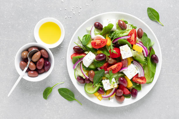 salada grega com verduras, azeitonas e feta xadrez em um prato branco, vista superior - queijo feta - fotografias e filmes do acervo