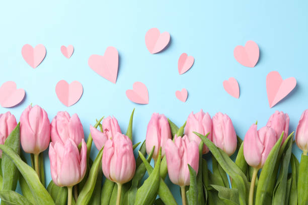 istock Pink tulips and decorative hearts on blue background, top view 1202693505