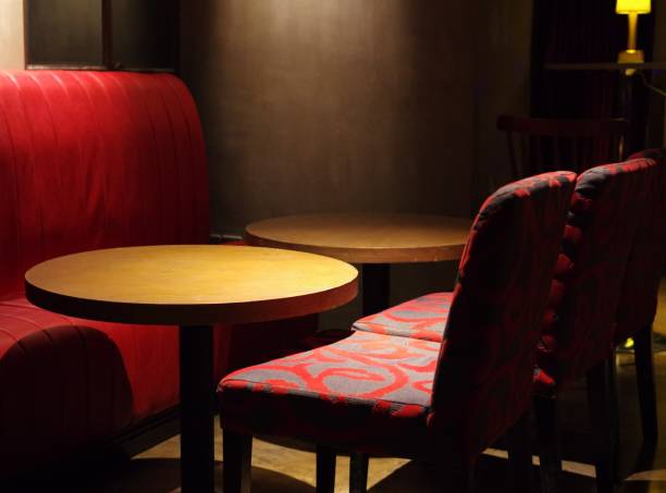 istock Empty lounge red sofa, fabric textile pattern chairs and round wood bar tables 1202694650