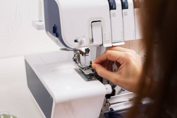 istock Women at work: Girl threading the needle of a sewing machine. 1202694885