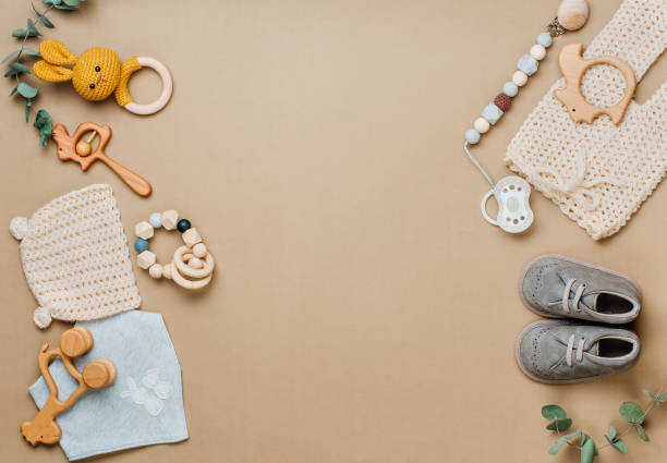 wooden toys, clothes and shoes on beige background - equipamento de bebê imagens e fotografias de stock