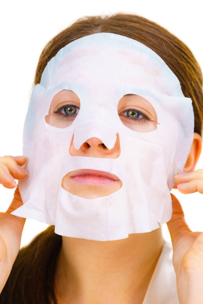 istock Woman applying sheet mask on face 1202697139