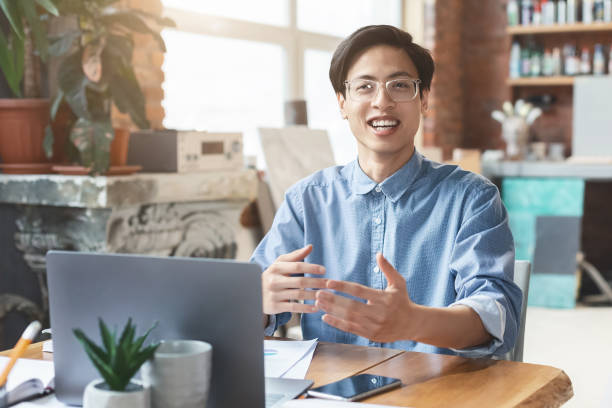 istock Happy asian guy sharing his ideas with colleagues 1202697668